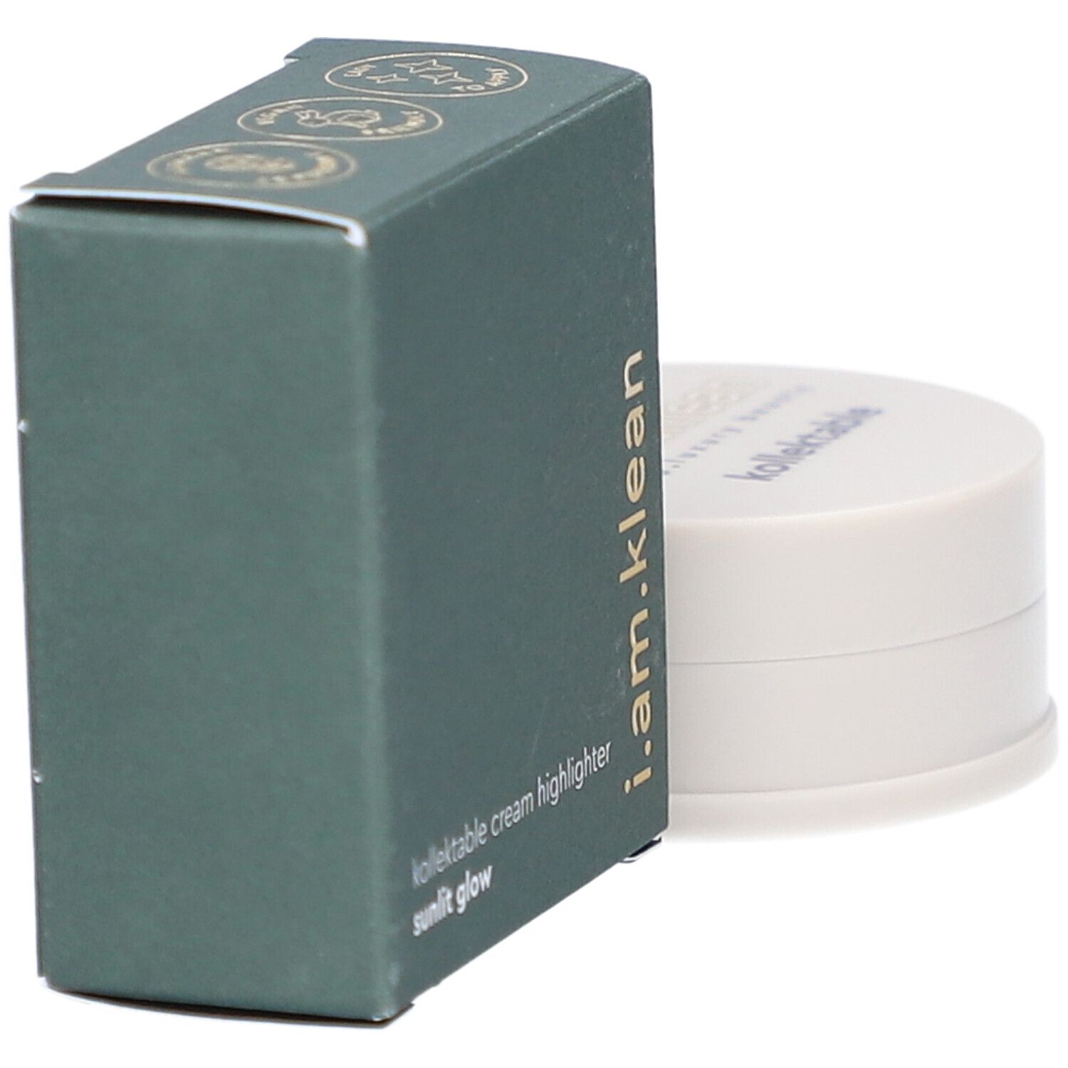 Boîte verte et contenant crème. La boîte porte i.am.klean, kollektable cream highlighter sunlit glow. Le contenant a un couvercle avec texte.
