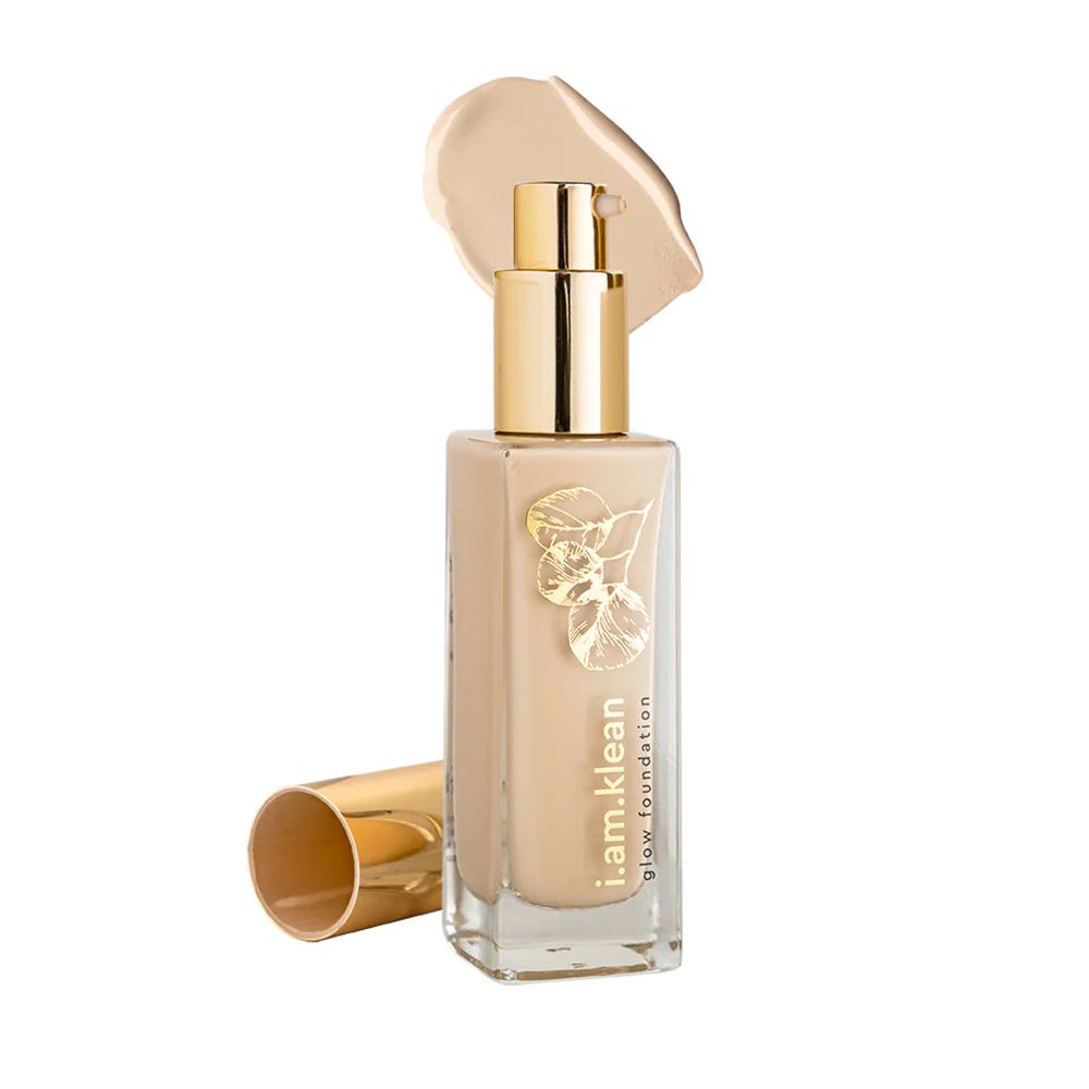 Fond de teint liquide avec bouchon doré et applicateur. Inscription : i.am.klean glow foundation. Tache de couleur beige.