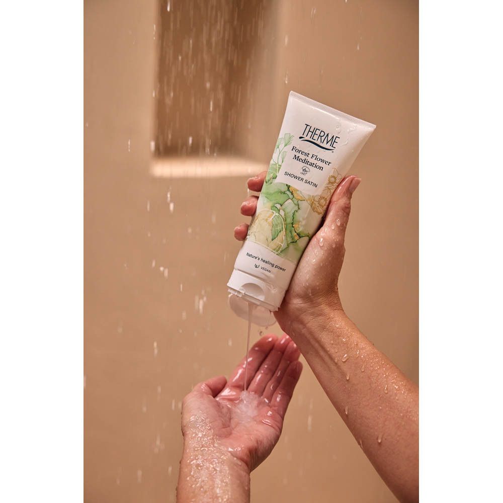 Mains tenant un tube. L'eau coule du tube. Le produit est un tube avec le logo THERME.