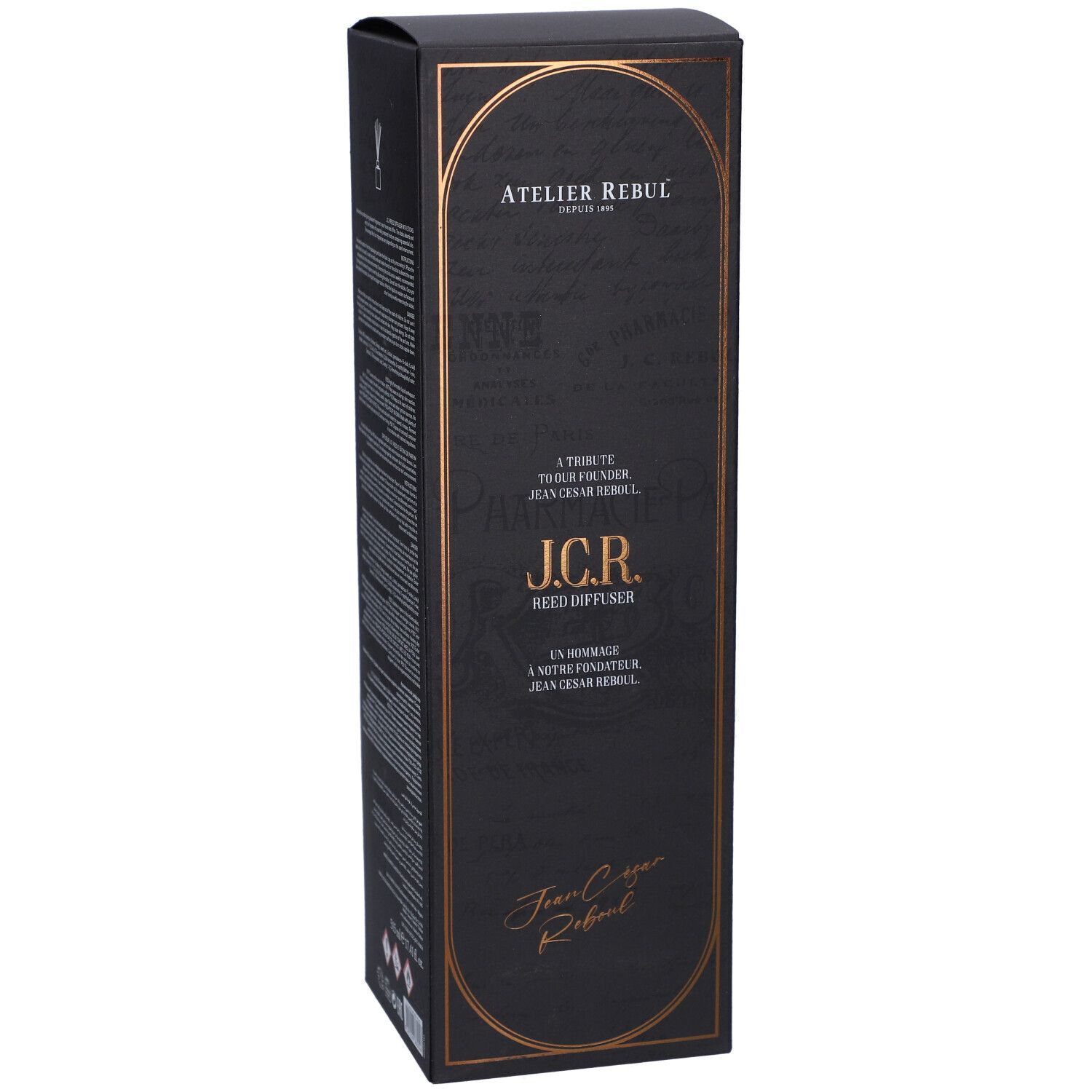 Boîte noire avec cadre doré. Texte : Atelier Rebul, J.C.R. Reed Diffuser. Signature : Jean Cesar Rebul.