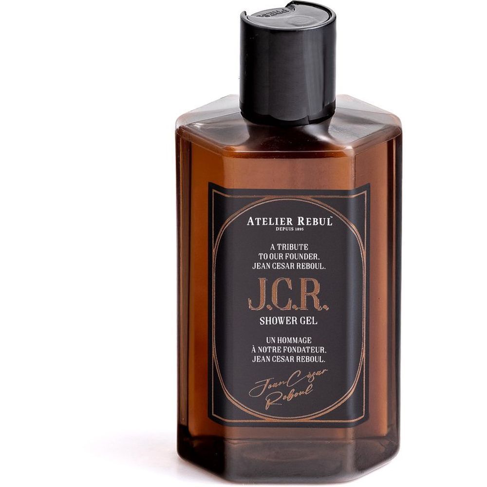 Flacon hexagonal marron avec bouchon noir. Étiquette avec texte: Atelier Rebul J.C.R. Shower Gel.