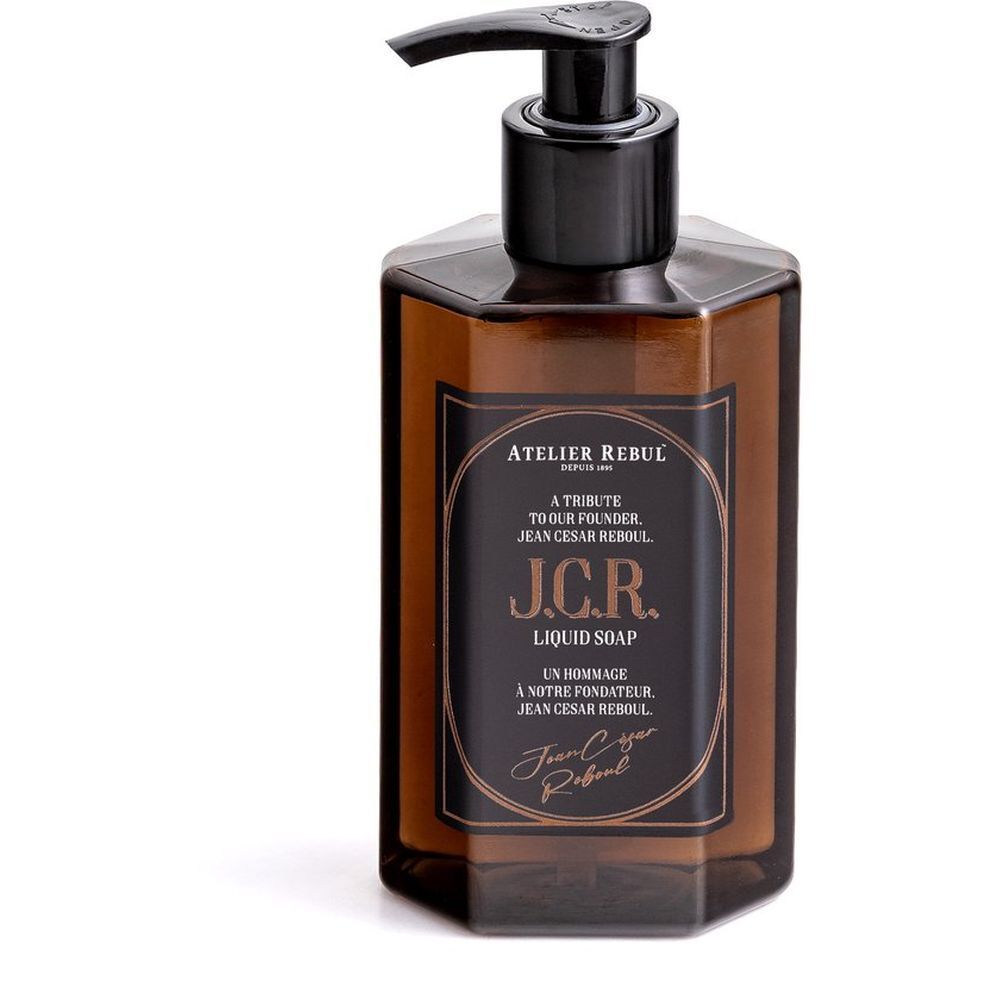 Flacon de savon liquide hexagonal brun avec pompe noire. Étiquette avec texte: Atelier Rebul J.C.R. Liquid Soap.