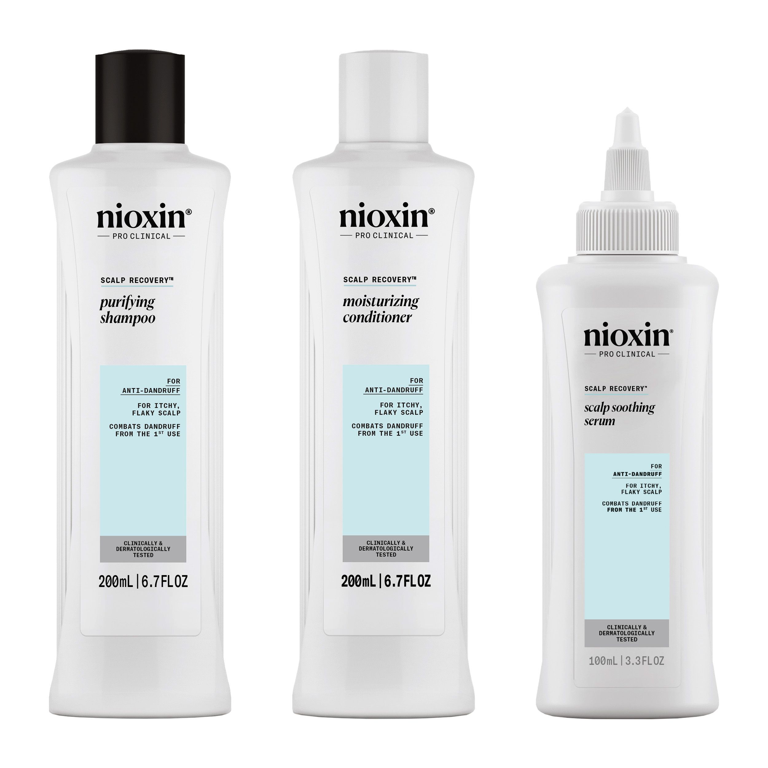 Trois produits Nioxin : shampooing, revitalisant et sérum. Bouteilles blanches avec étiquettes bleues. Bouchons noirs et blancs.