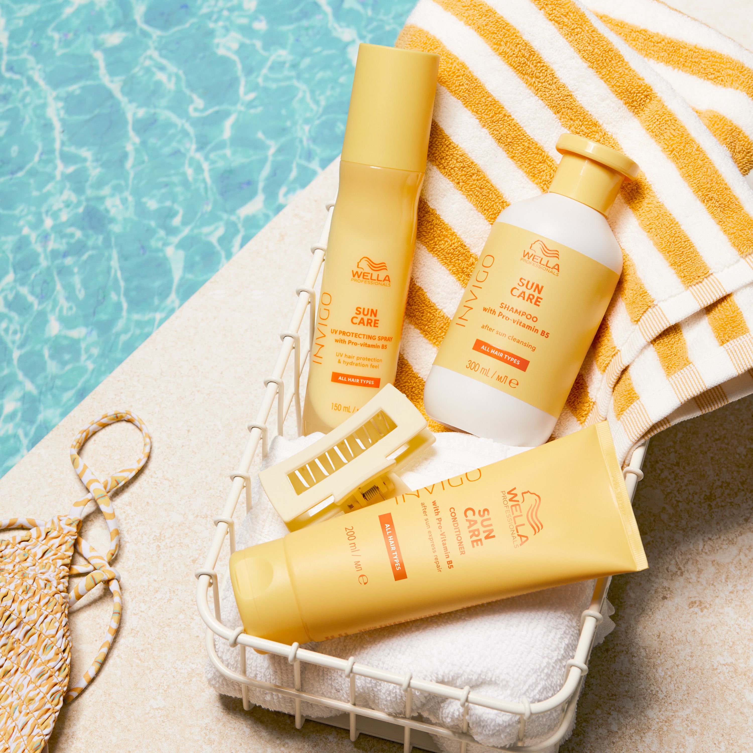 Panier avec produits Wella Invigo Sun Care: shampooing, après-shampooing, spray et brosse, sur serviette.