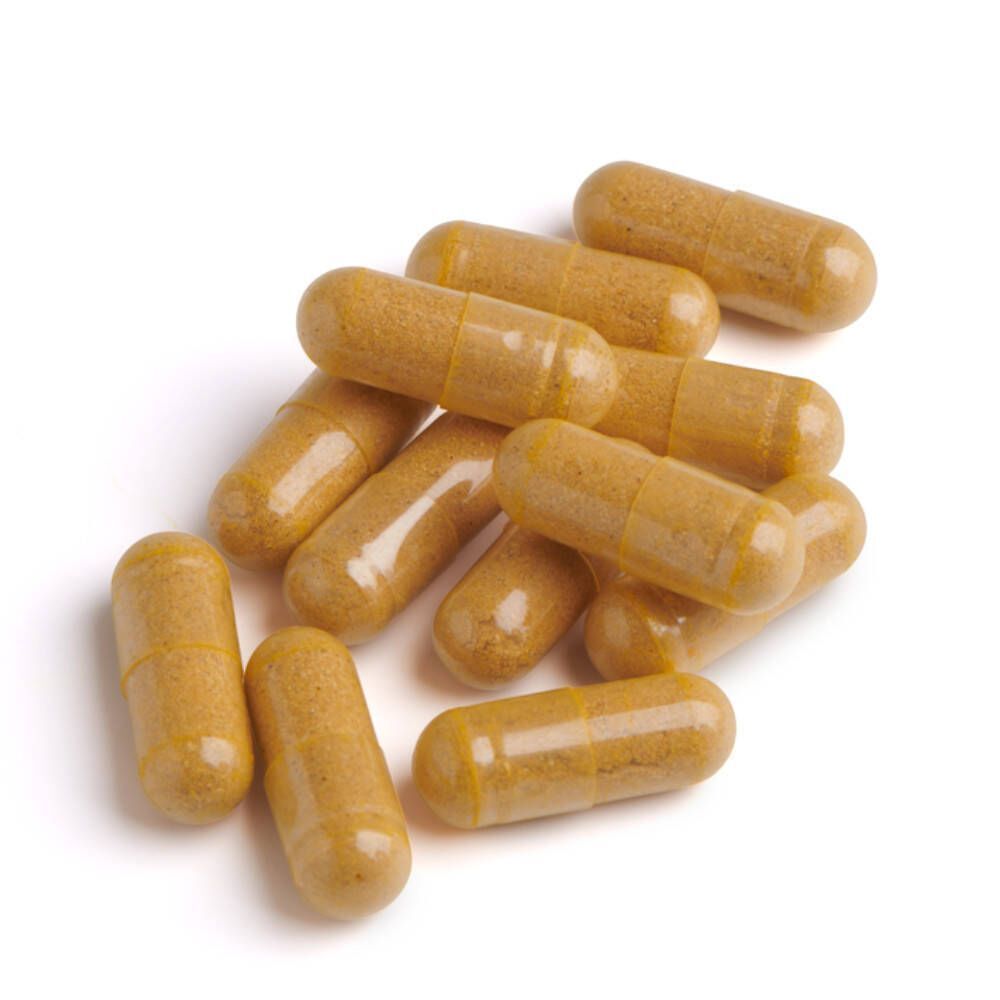 Tas de gélules jaunes. Aucun emballage ni inscription visible.