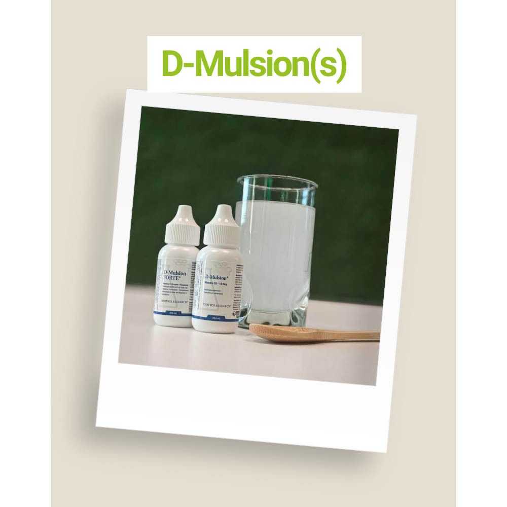 Deux flacons de D-Mulsion(s) à côté d'un verre de liquide et d'une cuillère.