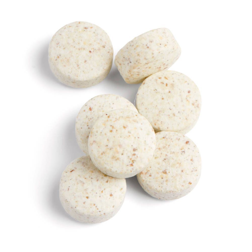 Sept comprimés ronds beiges. Vue de dessus. Comprimés avec particules visibles.