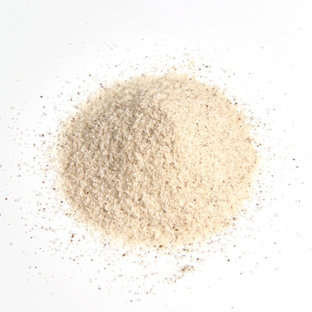 Tas de poudre brun clair sur fond blanc. Aucune inscription visible.