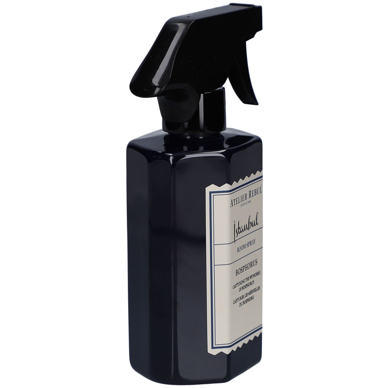 Flacon pulvérisateur bleu foncé, vue latérale. Tête de pulvérisation noire. Étiquette avec texte: Atelier Rebul Istanbul, Room Spray, Bosphorus.