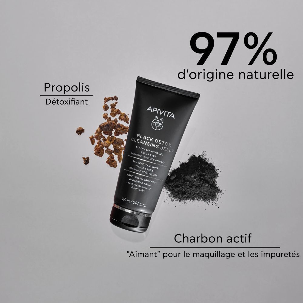 Un tube de gel nettoyant APIVITA Black Detox, à côté de charbon actif et de propolis. Texte: 97% d'origine naturelle.