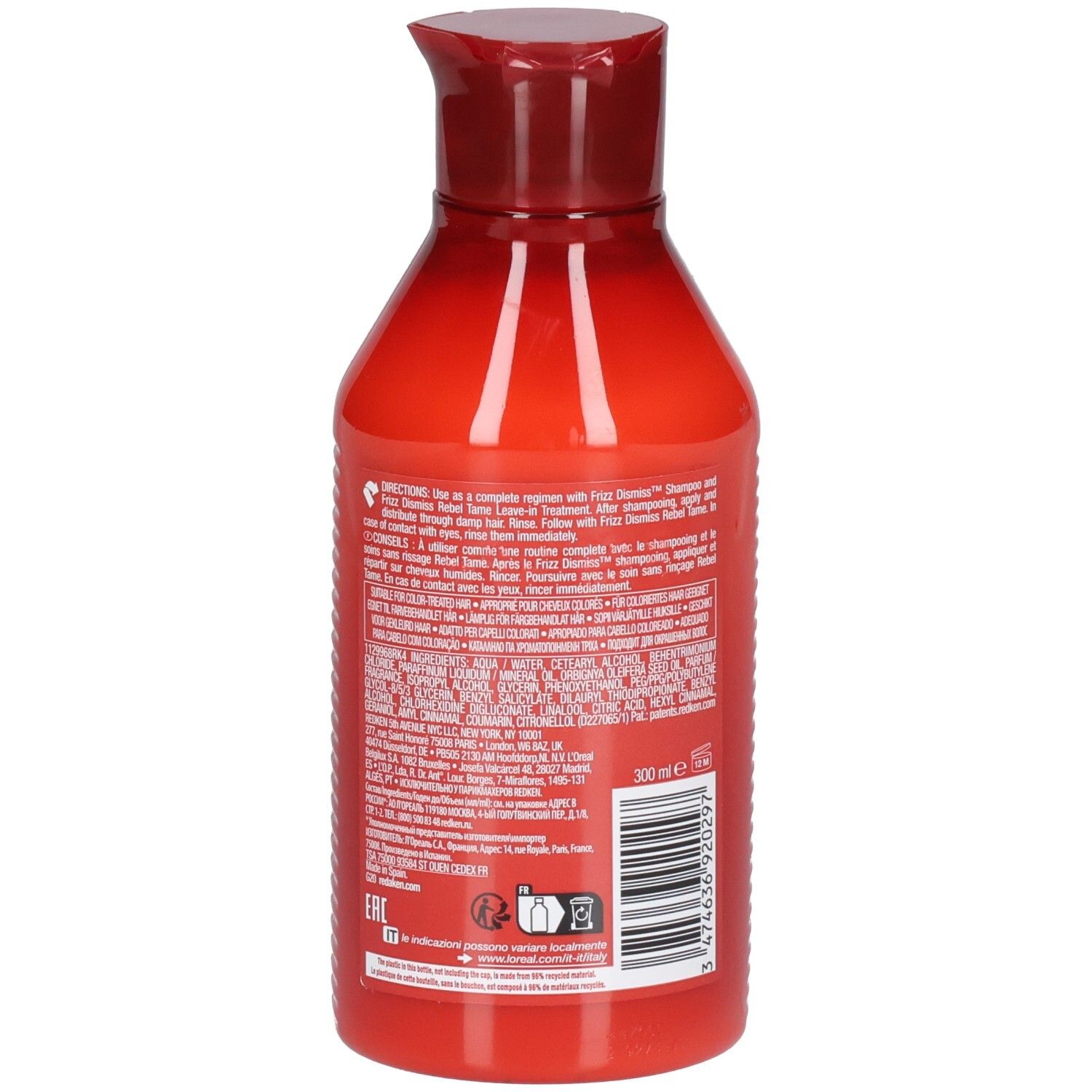 Dos du flacon rouge Redken Frizz Dismiss Conditioner. Texte multilingue. Code-barres et indication de volume.