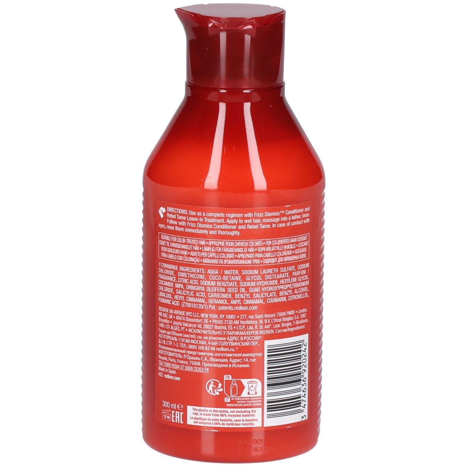 Dos d'un flacon de shampooing rouge. Contient du texte sur les ingrédients et l'utilisation. Code-barres et logo.