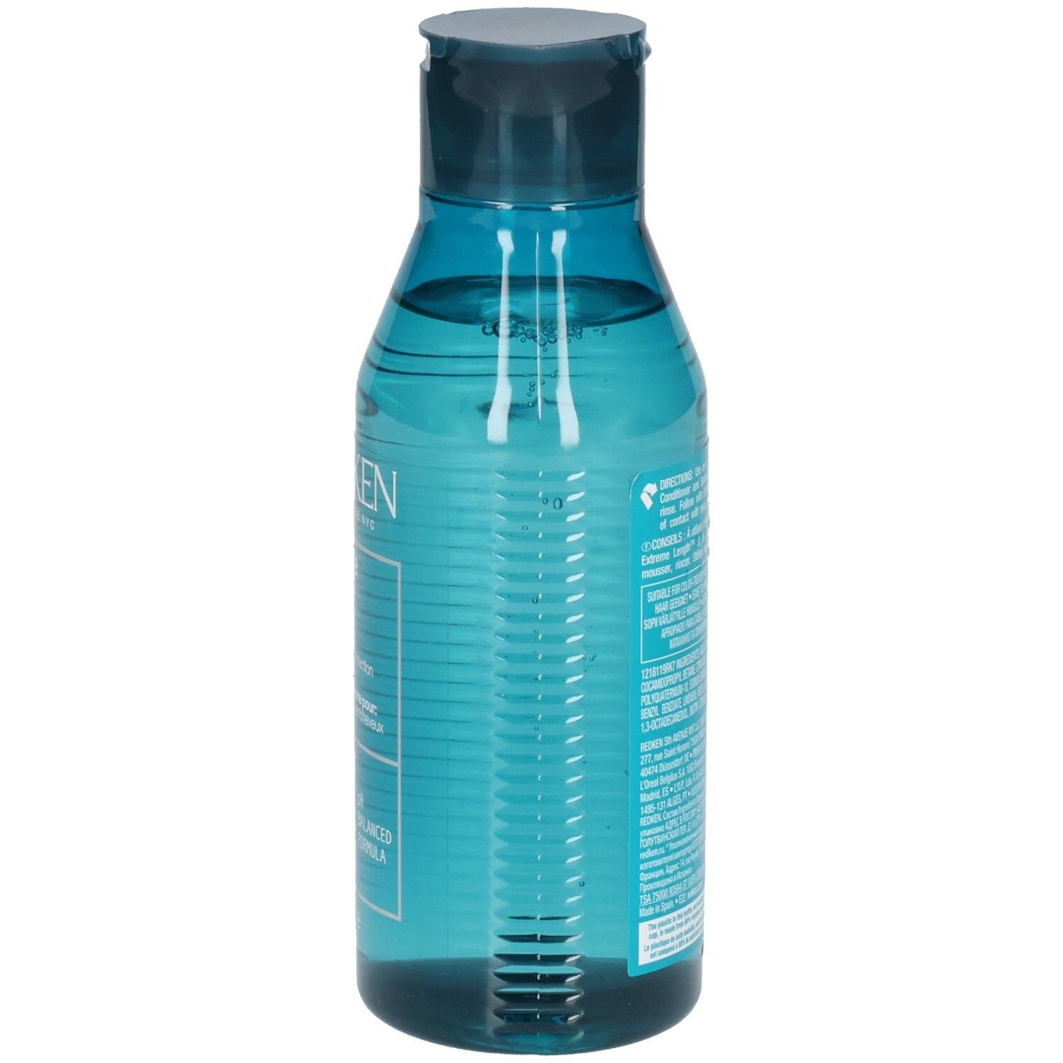Dos d'un flacon de shampooing bleu transparent. Code-barres et texte. Contient des ingrédients et des instructions.