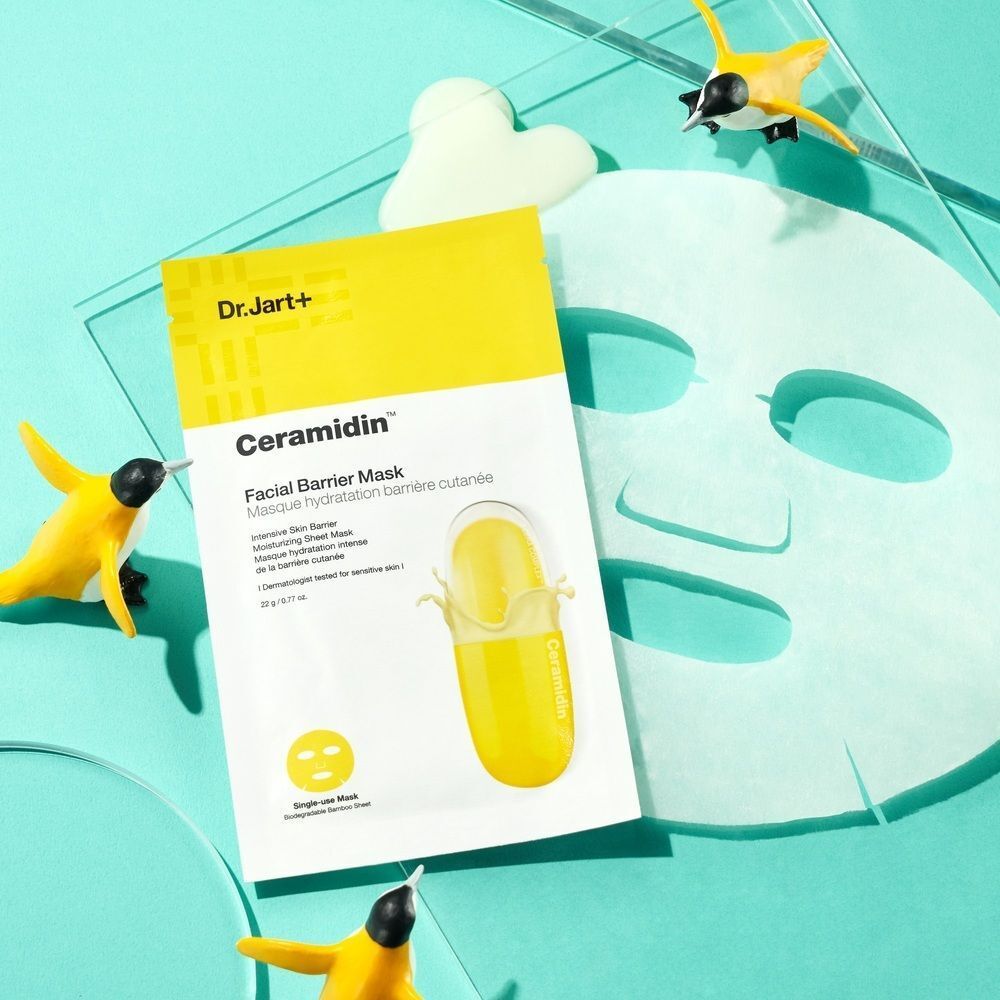 Masque facial Dr.Jart+ Ceramidin jaune sur fond bleu. Inscription: Facial Barrier Mask. Avec décoration.