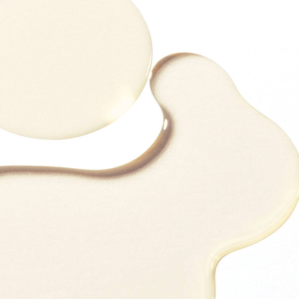 Deux gouttes d'huile sur fond blanc. Liquide clair et transparent.