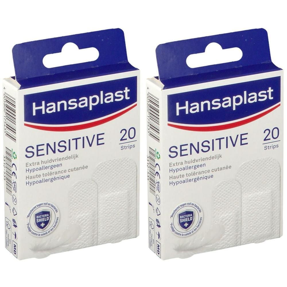 Deux boîtes de pansements Hansaplast SENSITIVE. Bandes blanches dans des boîtes ouvertes. Inscription: SENSITIVE, 20 Strips.