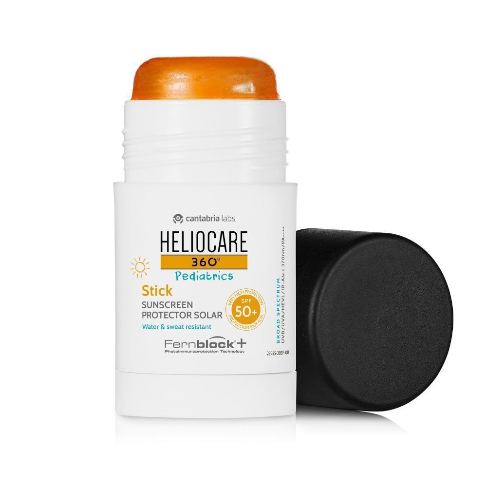 Stick de crème solaire avec bouchon noir ouvert. Crème solaire visible. Inscription: Heliocare 360° Pediatrics Stick SPF50+.