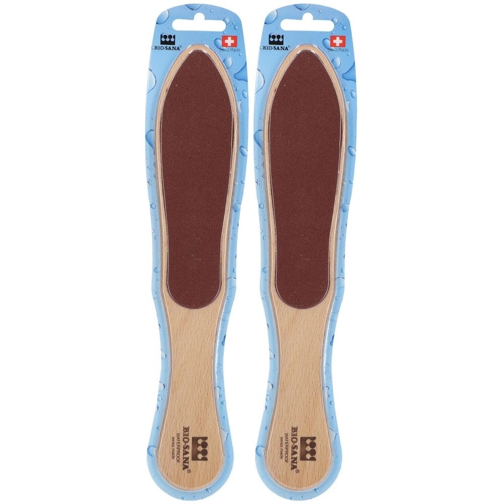 Deux limes à corne en emballage. Manche en bois, surface abrasive marron. Marque BIO-SANA, croix suisse.