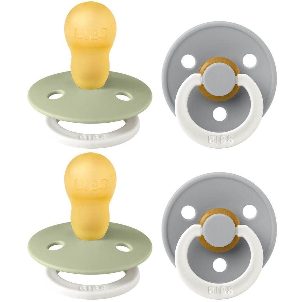 Quatre sucettes, deux vertes, deux grises. Forme ronde, tétine en silicone, anneau et bouclier. Logo BIBS visible.