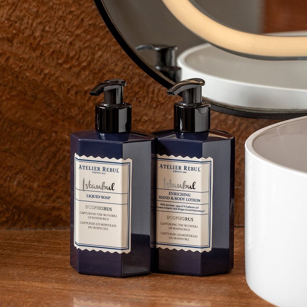 Deux distributeurs de savon bleu près d'un miroir. Un distributeur: Atelier Rebul Istanbul Bosphorus Liquid Soap.