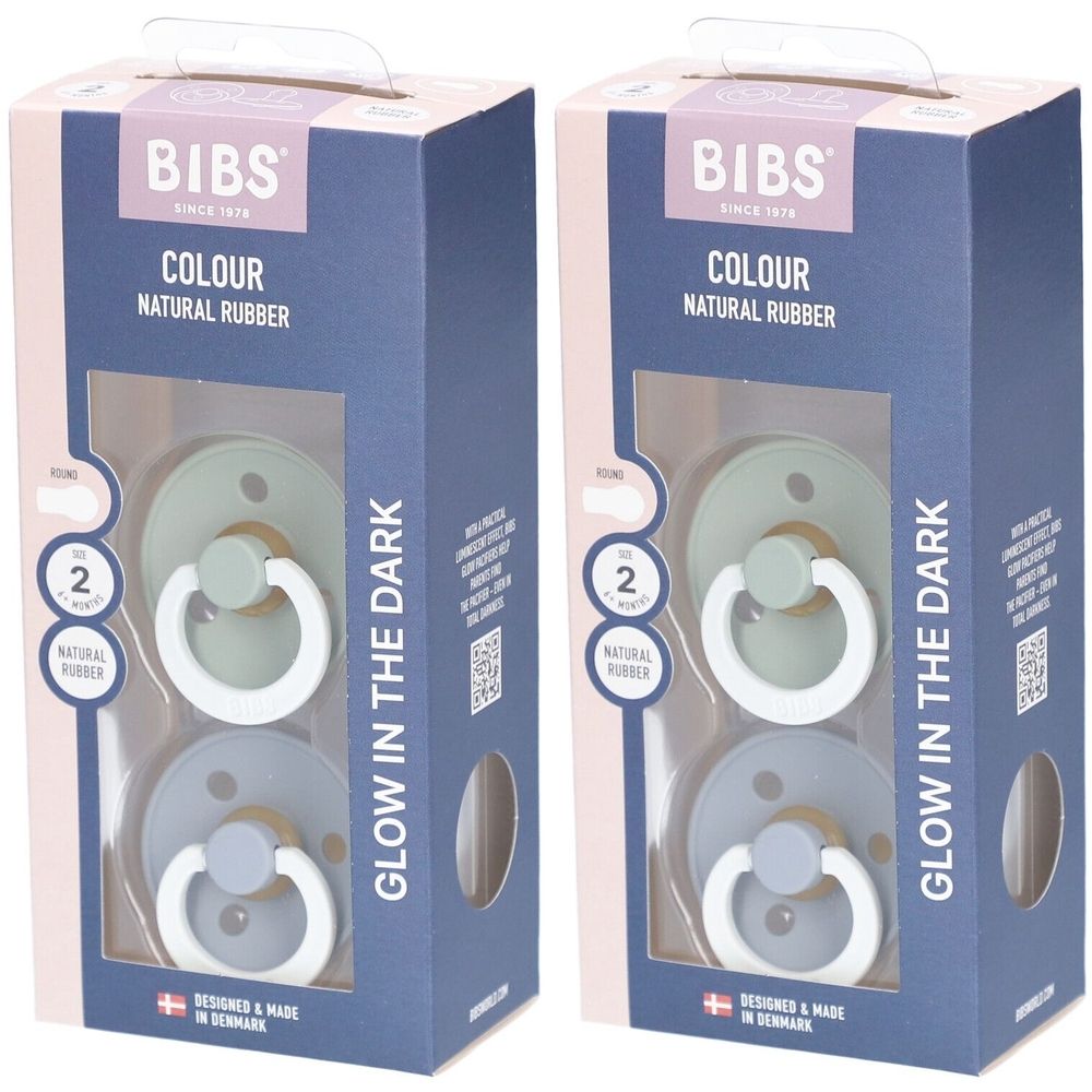 Deux sucettes BIBS COLOUR en emballage. Taille 2, caoutchouc naturel. Vert et bleu. Fenêtre. "GLOW IN THE DARK".
