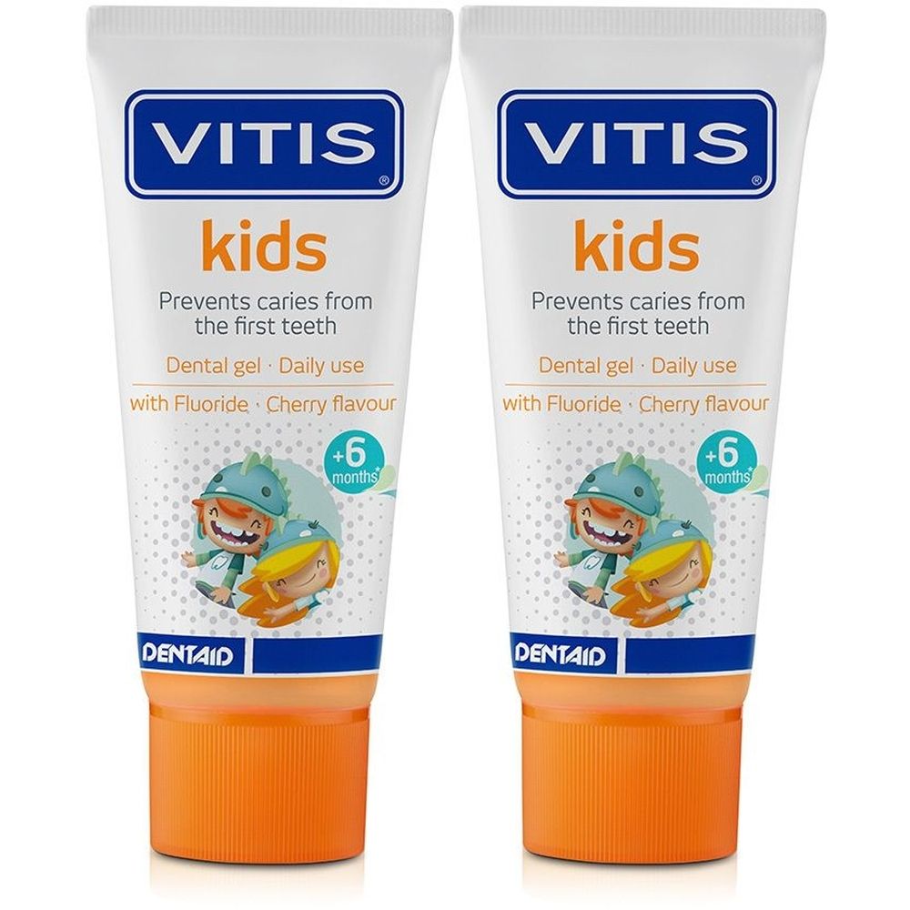 Deux tubes de gel dentaire VITIS Kids. Blanc, bouchon orange. Inscription : Kids, prévient les caries, au fluor, goût cerise. Dès 6 mois.