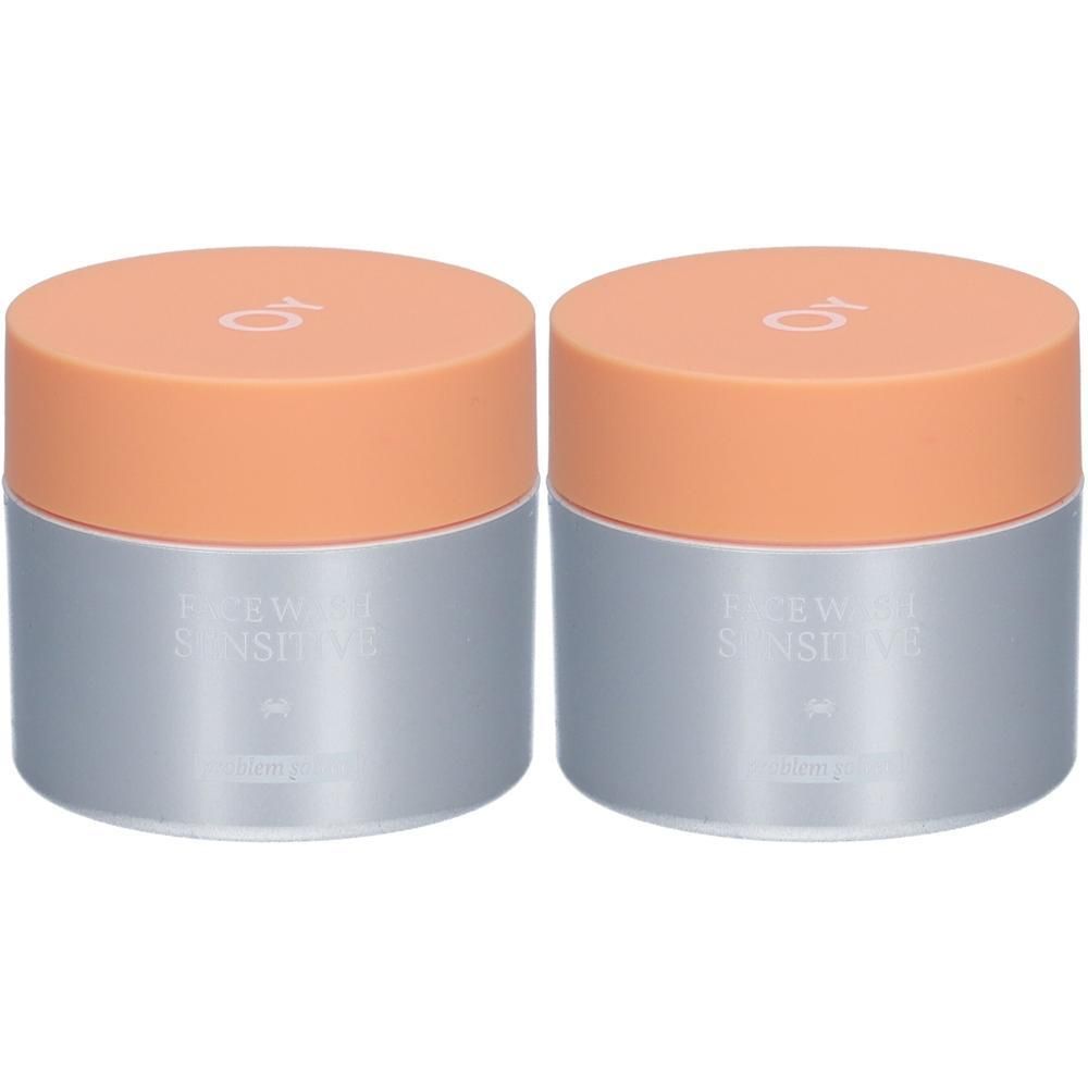Deux pots avec couvercles orange. L'inscription "FACE WASH SENSITIVE" est visible.