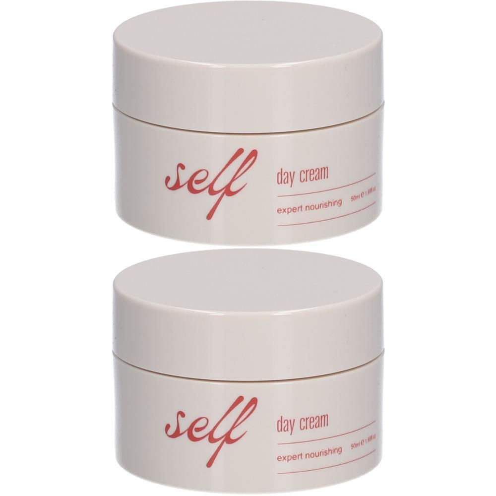 Deux pots crème avec texte rouge: "self day cream expert nourishing". Couvercles arrondis.