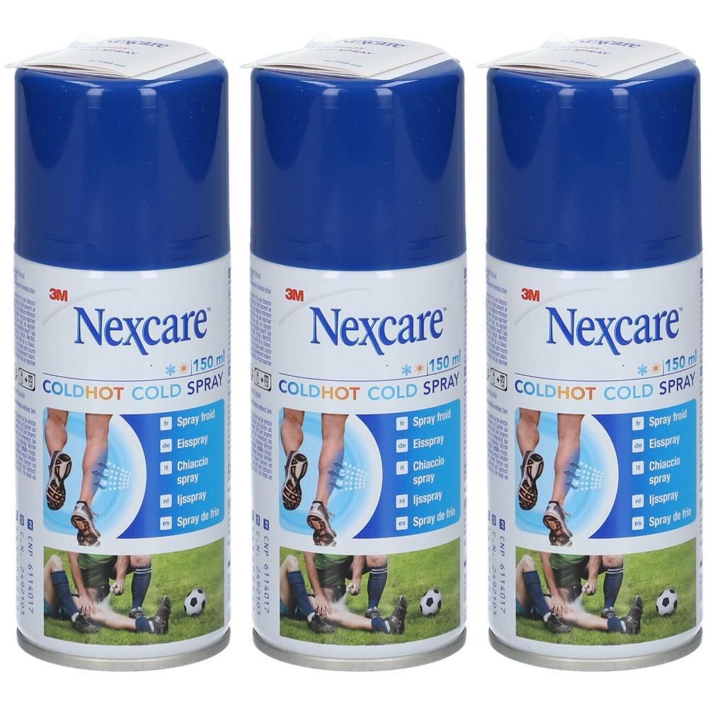 Trois flacons de spray Nexcare Coldhot. Bouchons bleus, étiquettes blanches avec nom et illustrations. Sur gazon.