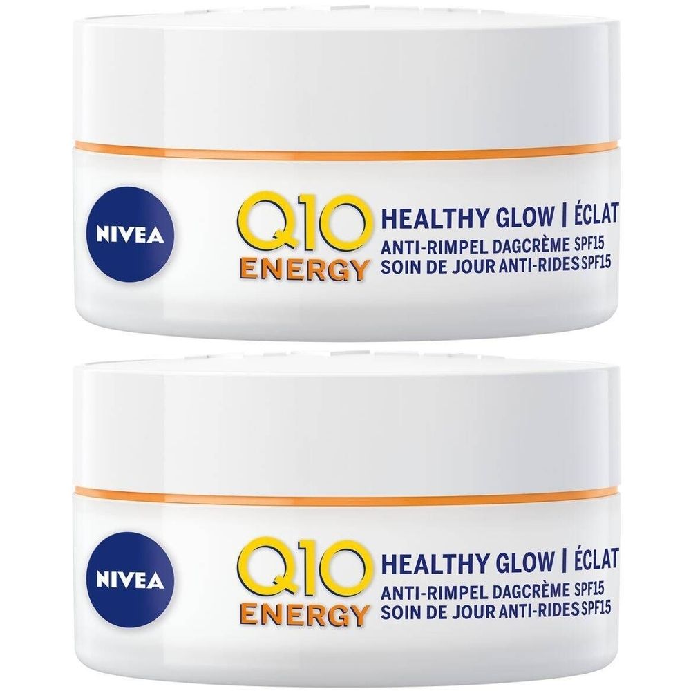 Deux pots blancs avec bande orange et logo bleu NIVEA. Inscription jaune Q10 ENERGY, texte Healthy Glow, crème de jour anti-rides SPF15.
