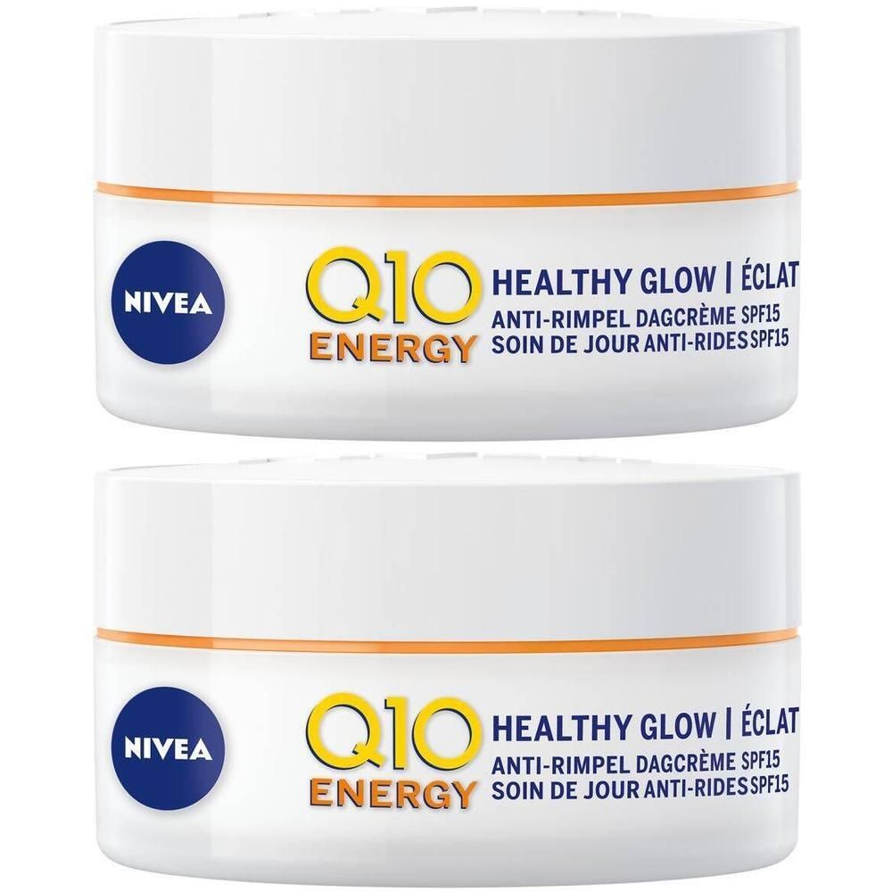 Deux pots blancs avec bande orange et logo bleu NIVEA. Inscription jaune Q10 ENERGY, texte Healthy Glow, crème de jour anti-rides SPF15.