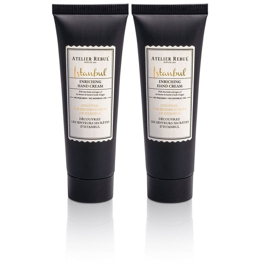 Deux tubes noirs de crème pour les mains avec étiquette blanche. Inscription : ATELIER REBUL Istanbul Enriching Hand Cream.