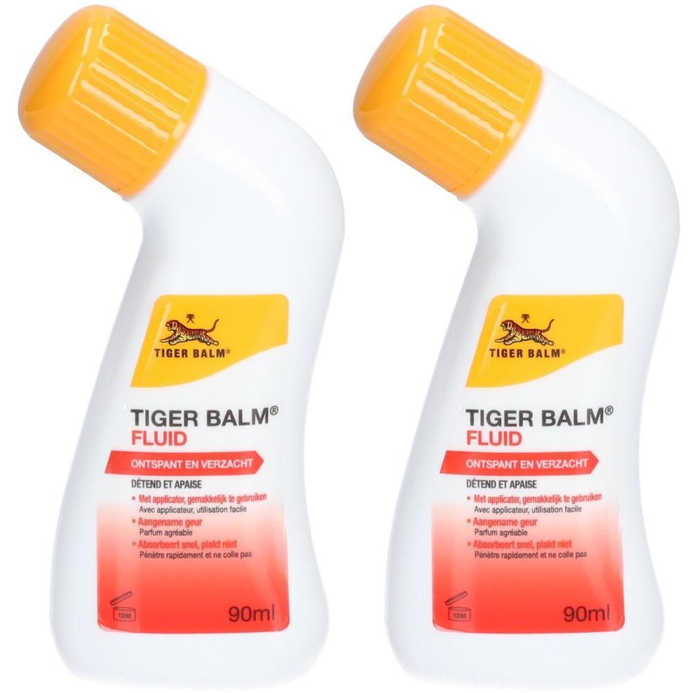 Deux flacons de Tiger Balm® Fluid. Flacons blancs avec bouchons jaunes. Inscriptions rouges et jaunes. 90ml.