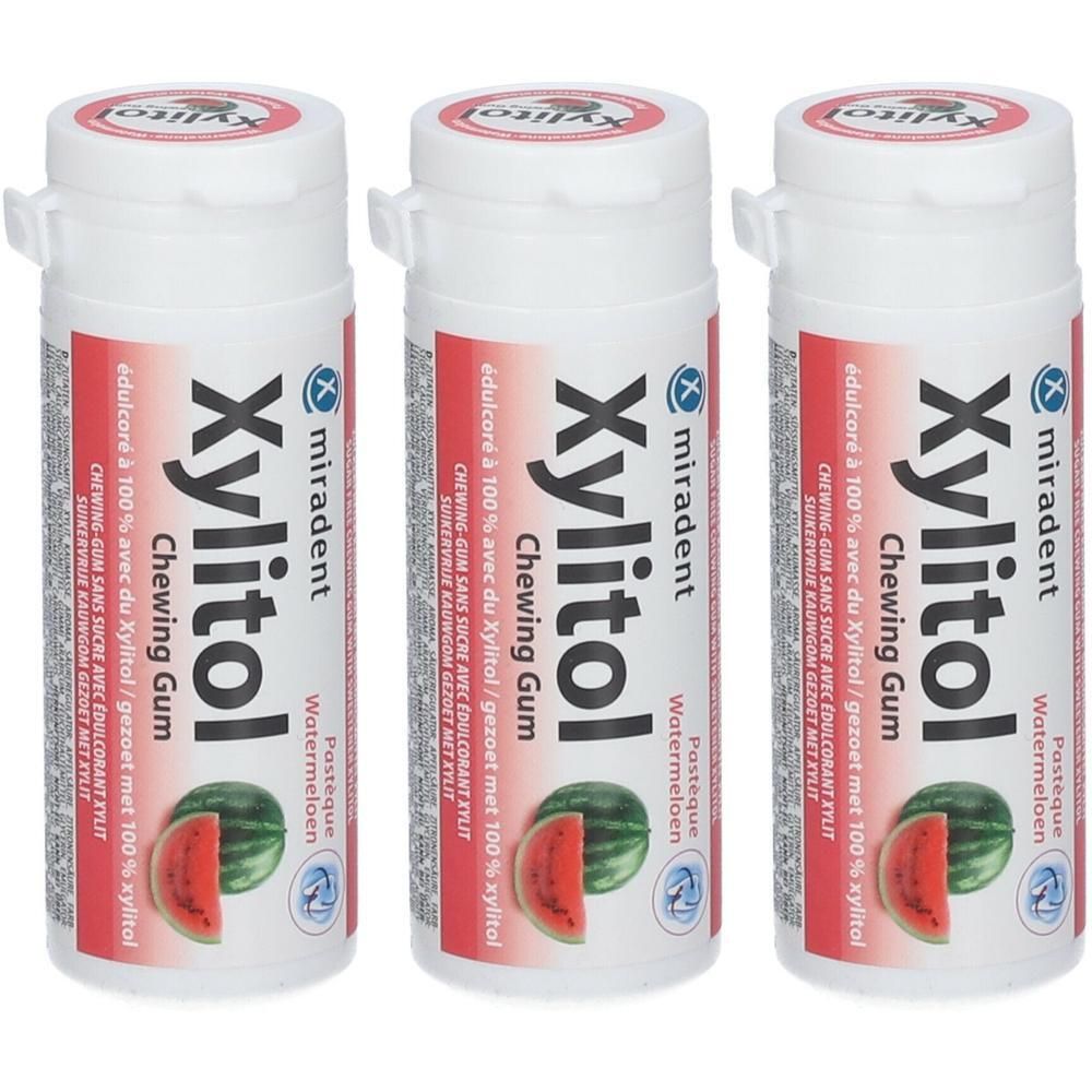 Trois flacons blancs de chewing-gum miradent Xylitol. Impression rouge avec nom du produit et illustration de pastèque.
