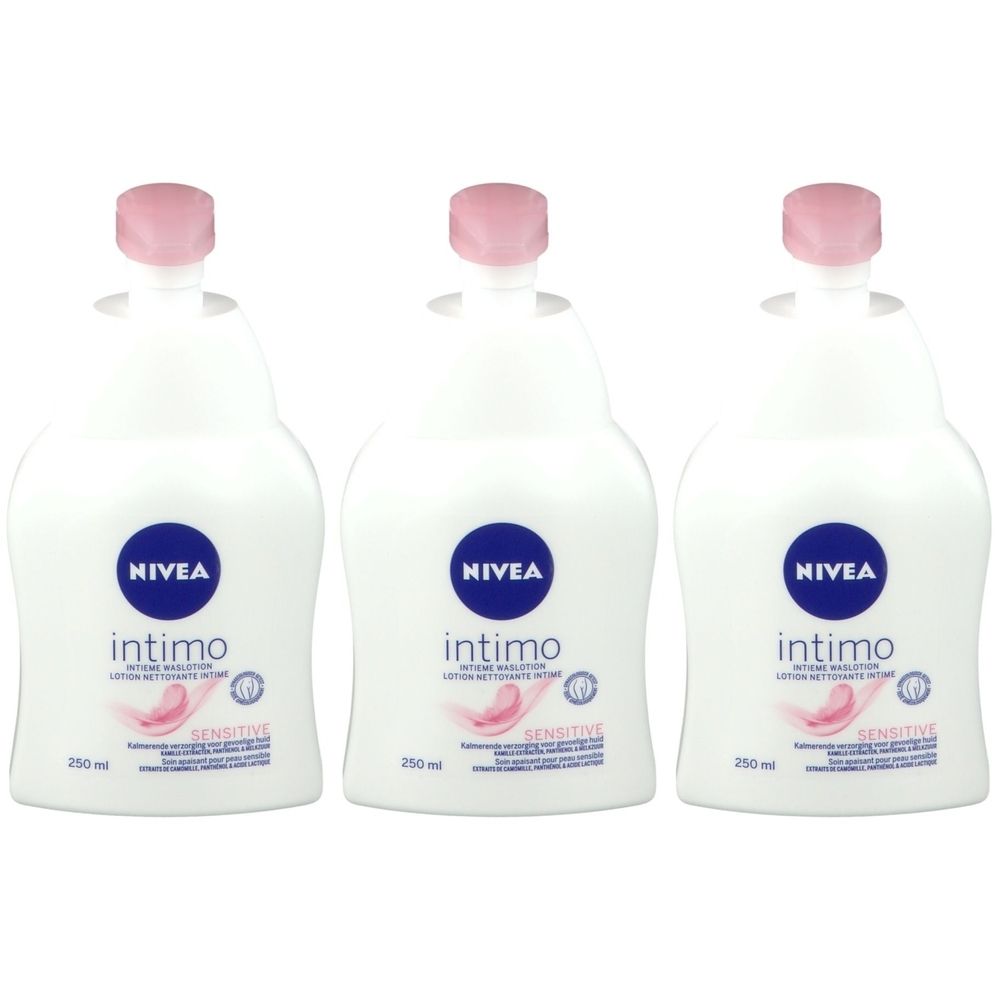 Trois flacons blancs de lotion Nivea Intimo Sensitive. Étiquettes bleues avec logo et nom du produit. Bouchons roses.
