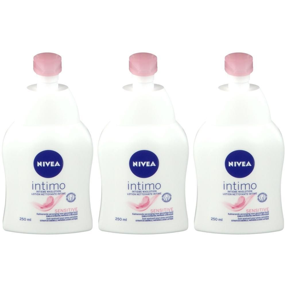 Trois flacons de lotion NIVEA Intimo Sensitive. Flacons blancs avec bouchons et étiquettes roses. Cercles de logo bleus.