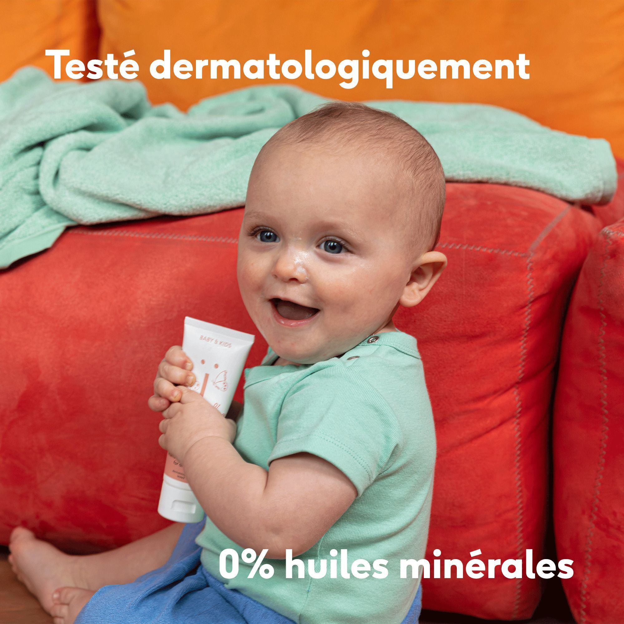 Bébé souriant tenant un tube de Crème Riche NAÏF, avec texte '0% huiles minérales'.