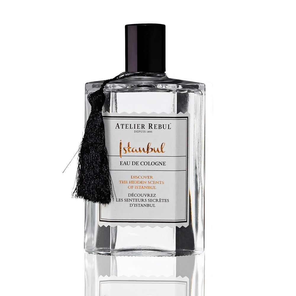 Flacon ATELIER REBUL Istanbul Eau de Cologne. Forme rectangulaire, bouchon noir, pompon. Inscription : Istanbul Eau de Cologne.