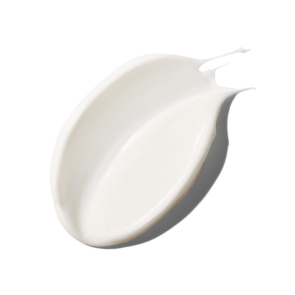 Une goutte de crème sur fond blanc. La crème est blanche et a une texture lisse.