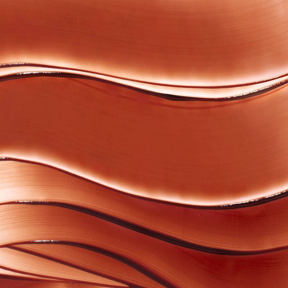Gros plan sur des traits de gel bronzé ondulés. Texture avec reflets de lumière.