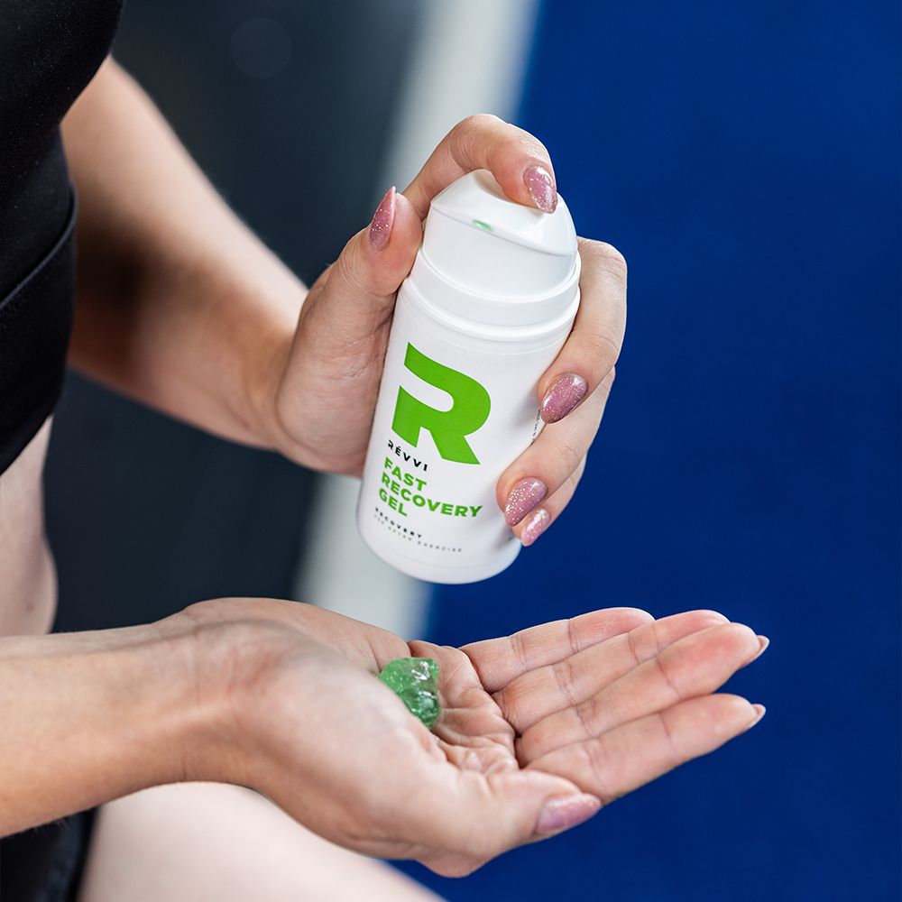 Femme tenant un flacon blanc et du gel dans la main. "RÉVVI Fast Recovery Gel" visible. Fond bleu.