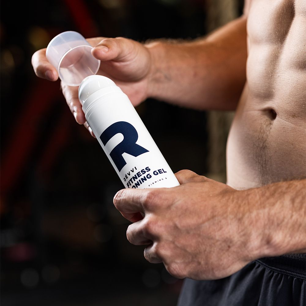 Personne tenant flacon blanc avec "R" bleu et texte: RÉVVI Fitness Toning Gel. Bouchon ouvert.