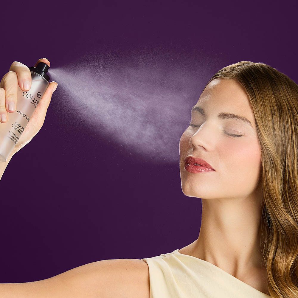 Femme vaporisant le produit sur son visage. Flacon avec vaporisateur noir. Fond violet.