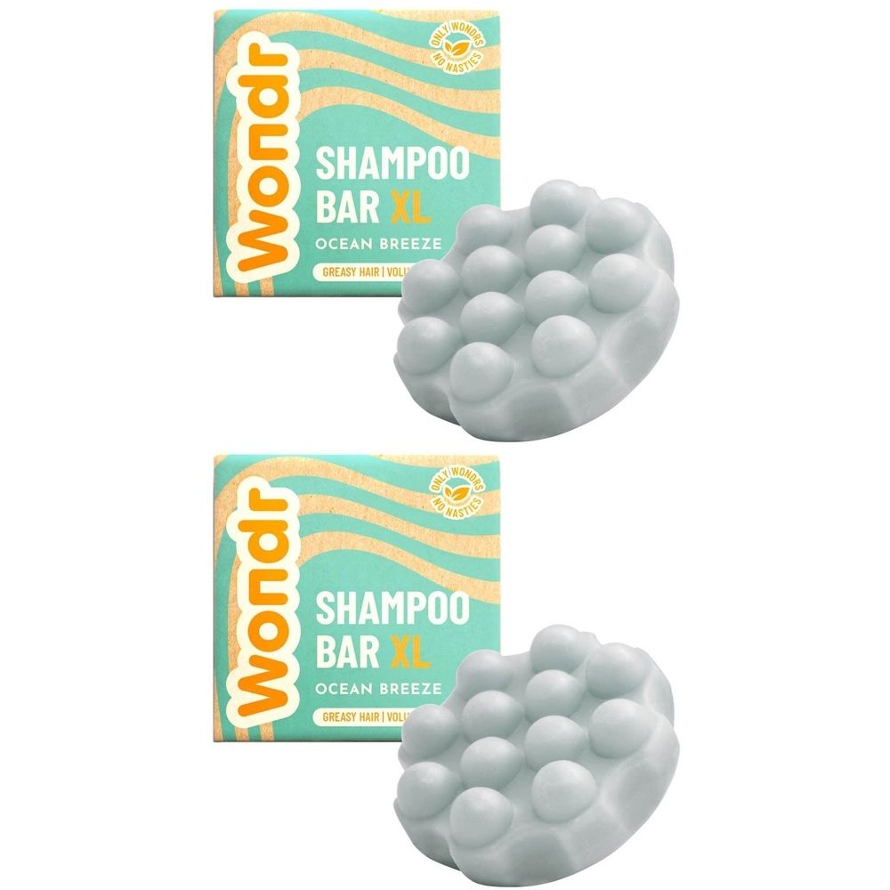 Deux barres de shampooing XL et emballages. Forme ronde gris clair avec des bosses. Emballage avec le texte Wondr et Shampoo Bar.