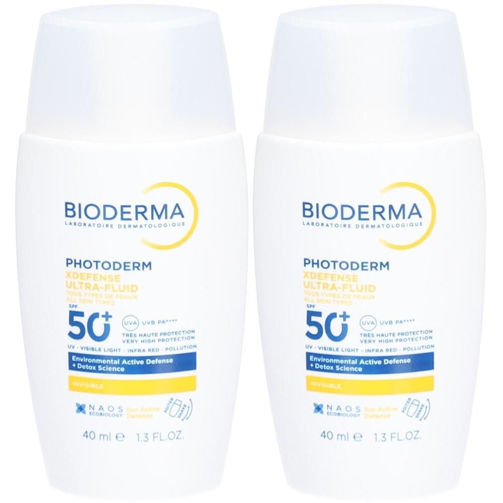Deux flacons blancs avec inscriptions bleues et jaunes. Inscription: Bioderma Photoderm X-Defense Ultra-Fluid SPF 50+.