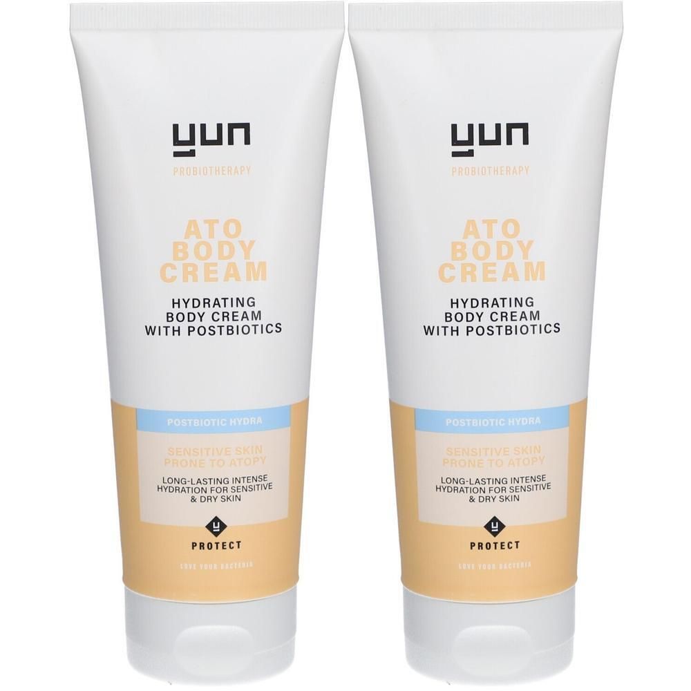 Deux tubes de YUN ATO Body Cream. Tubes blancs avec texte et informations produit. Accents beiges et bleu clair.