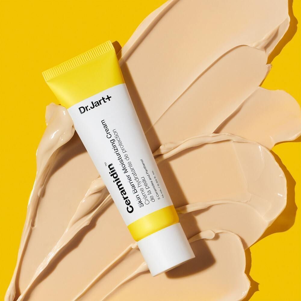 Tube de Dr.Jart+ Ceramidin Skin Barrier Moisturizing Cream sur fond jaune. Texture de crème au premier plan.