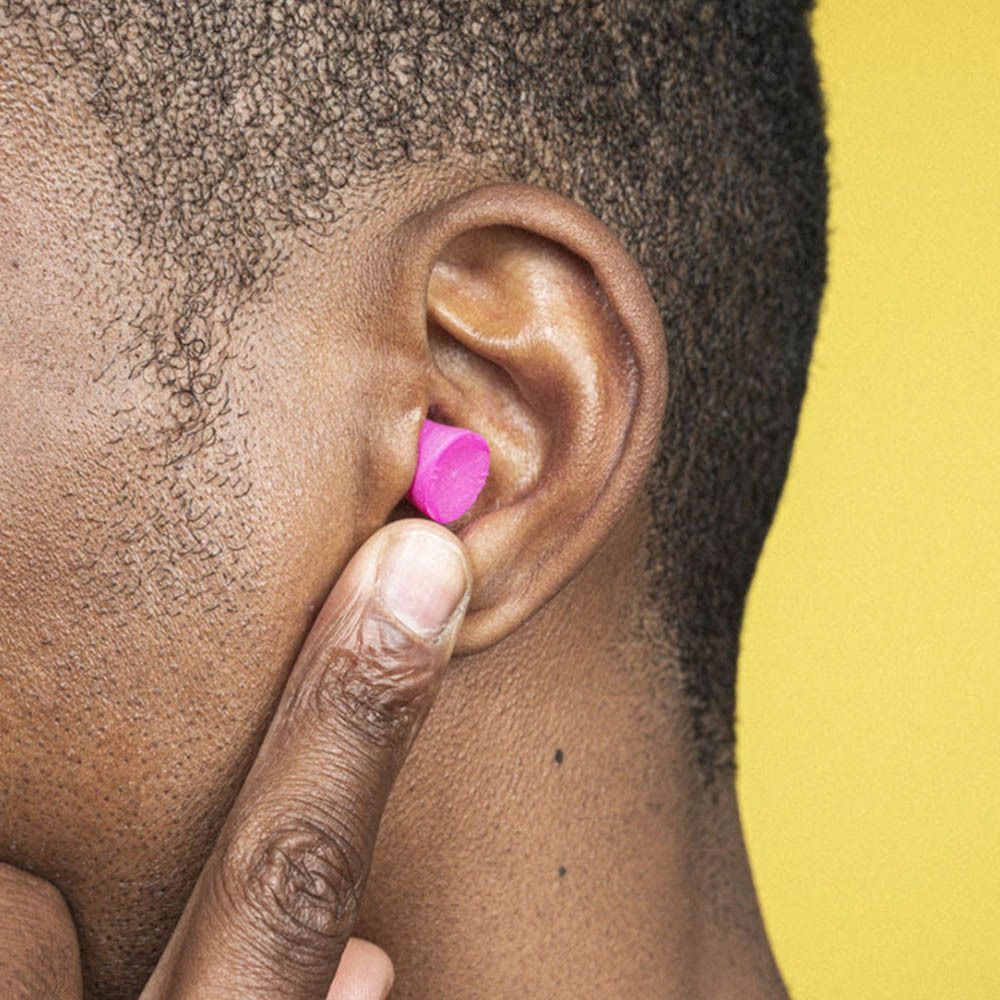 Un homme insère un bouchon d'oreille en mousse blox® rose, petit.