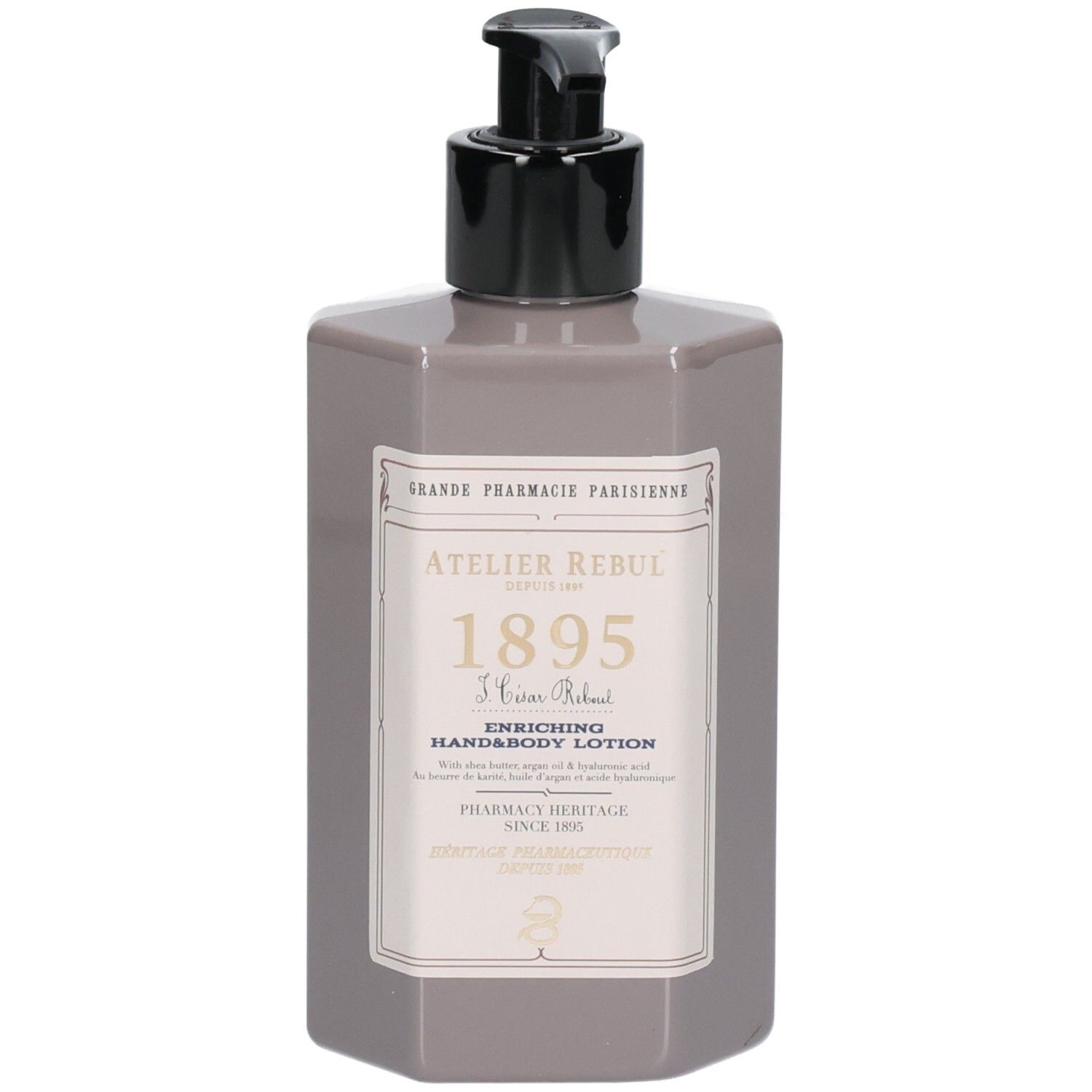 Flacon hexagonal gris avec pompe noire. Étiquette avec texte: Atelier Rebul 1895, lotion mains et corps. Logo de pharmacie.