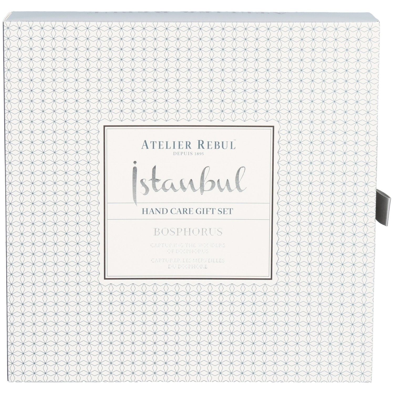 Emballage d'un coffret cadeau pour les mains avec motif géométrique et écriture argentée.